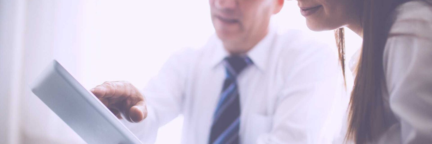 Man and woman reviewing data on tablet