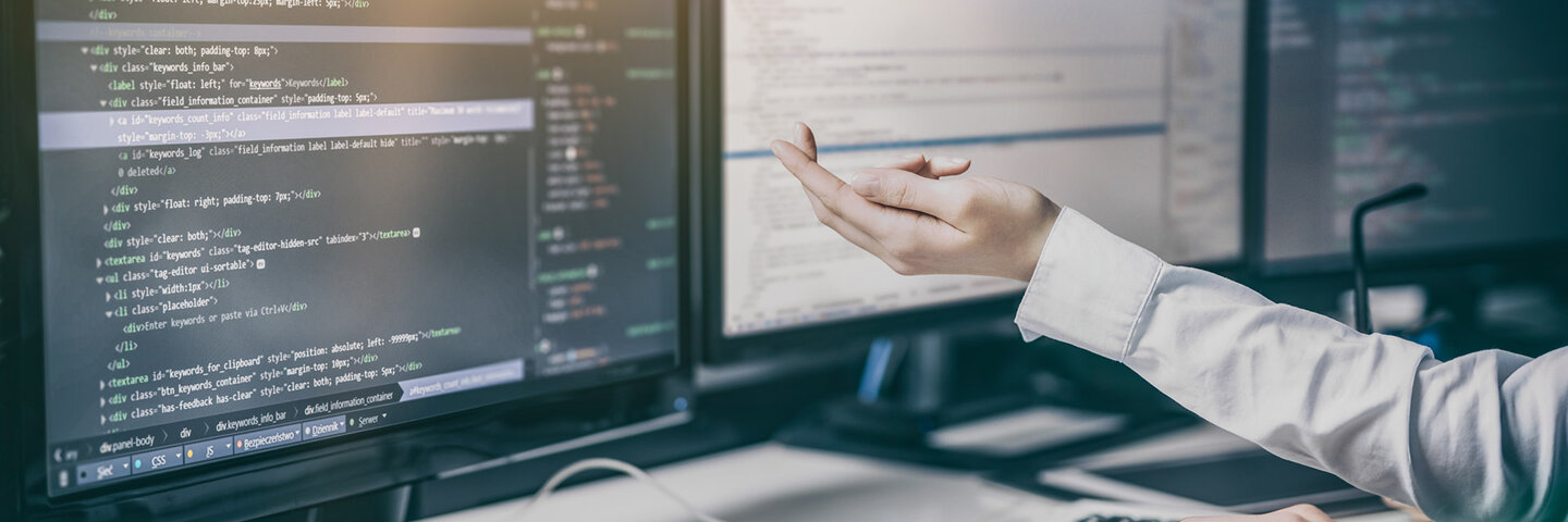 hand pointing to html and css code on screen