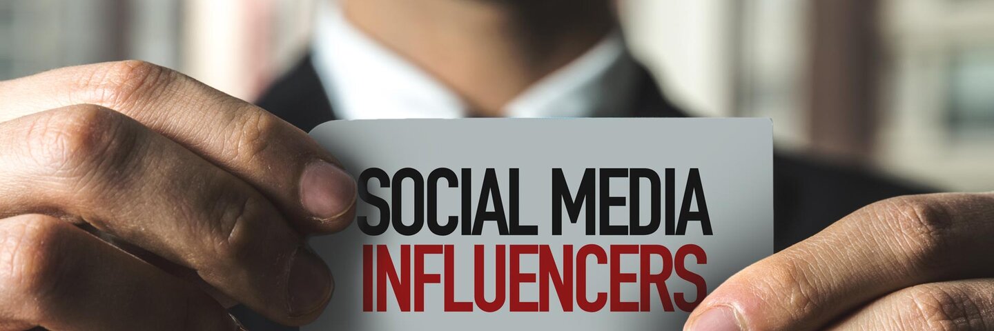 man holding card with text that reads "social media influencers"
