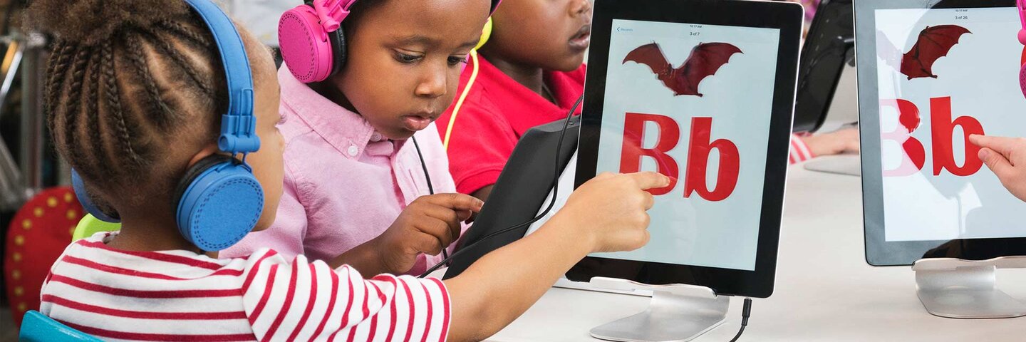 Students learning alphabet with digital tablets