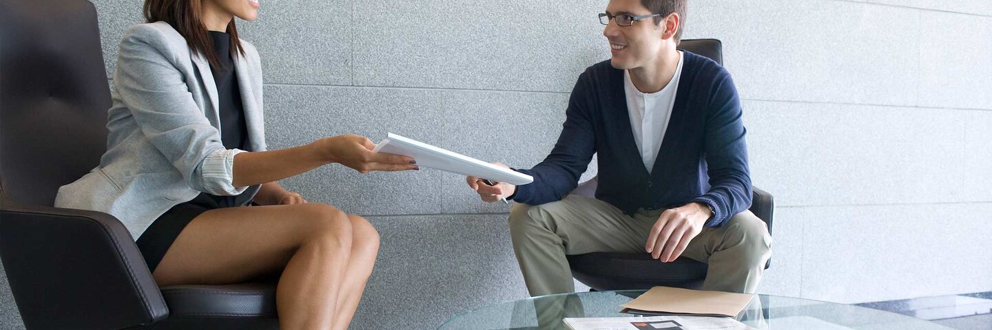 Businesswoman handing documents to client
