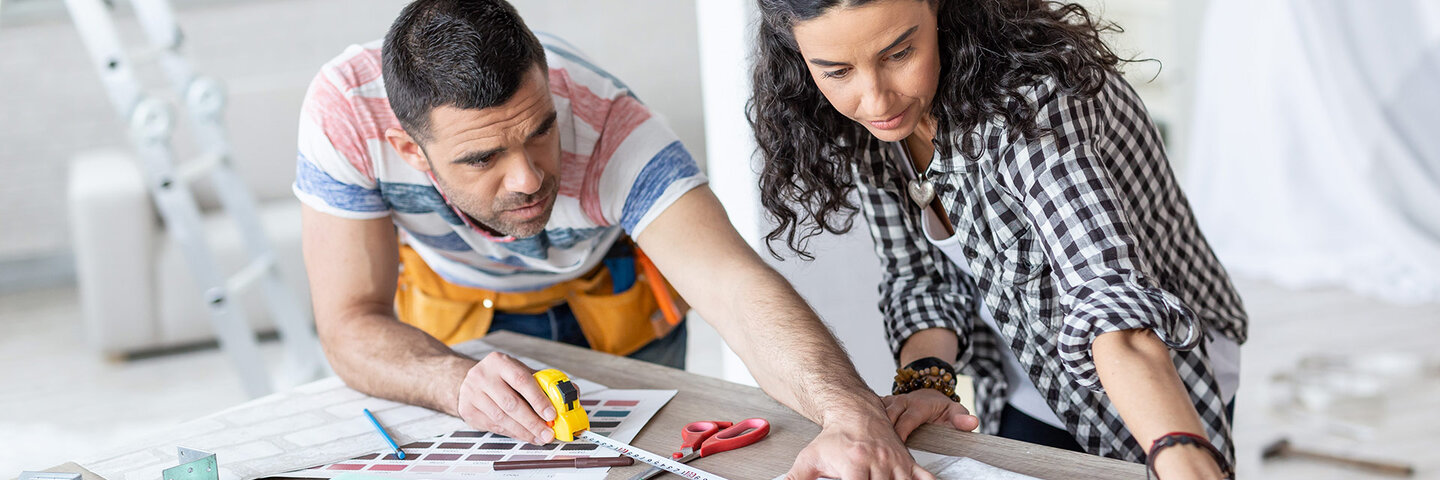 man and woman measuring space during a remodel