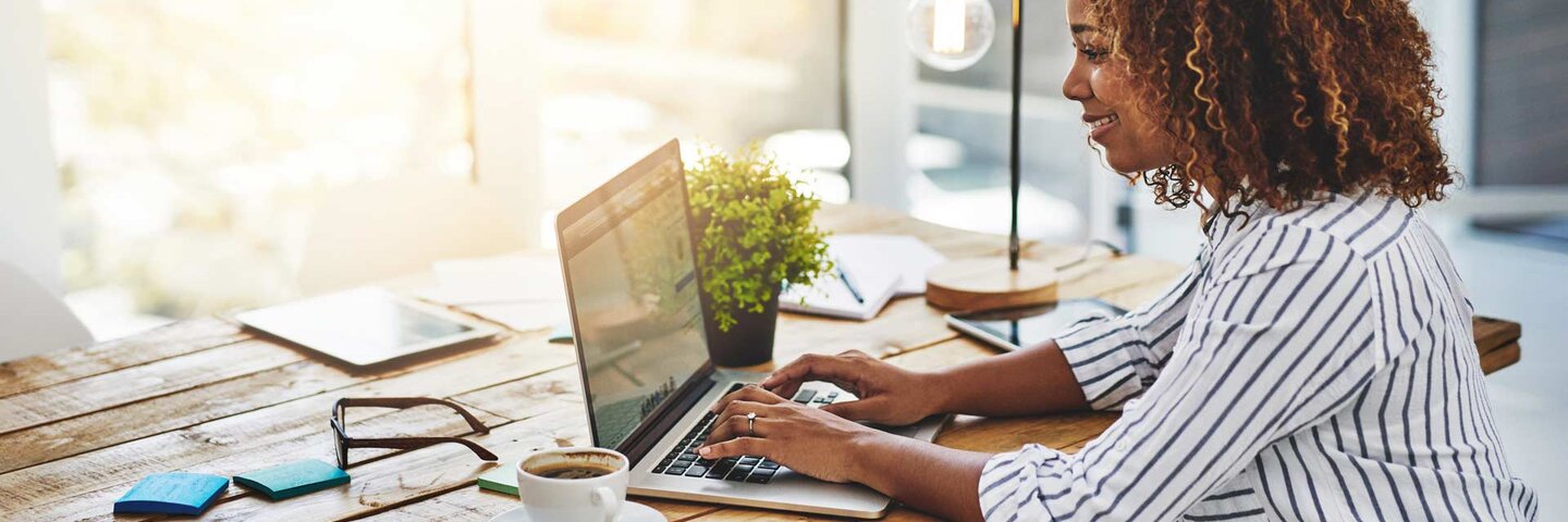woman using laptop with bright light behind her