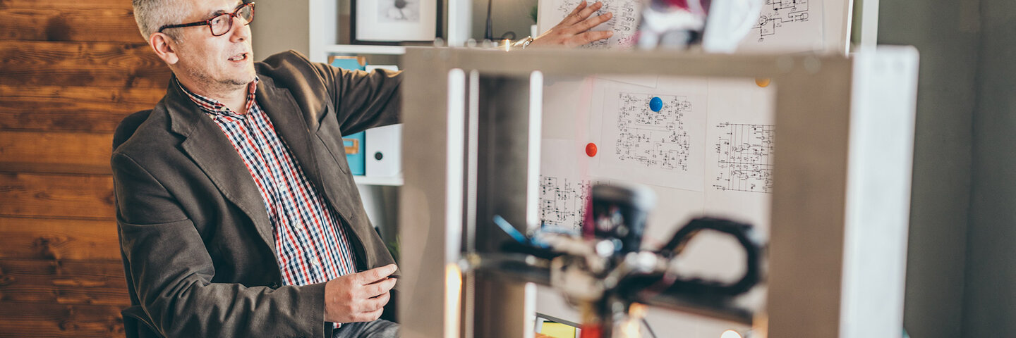 Man discussing manufacturing plan with 3-d printed model