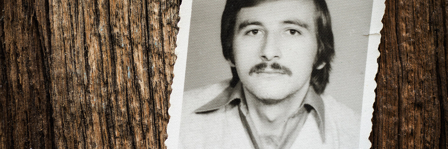 black and white photo of man on a wood background