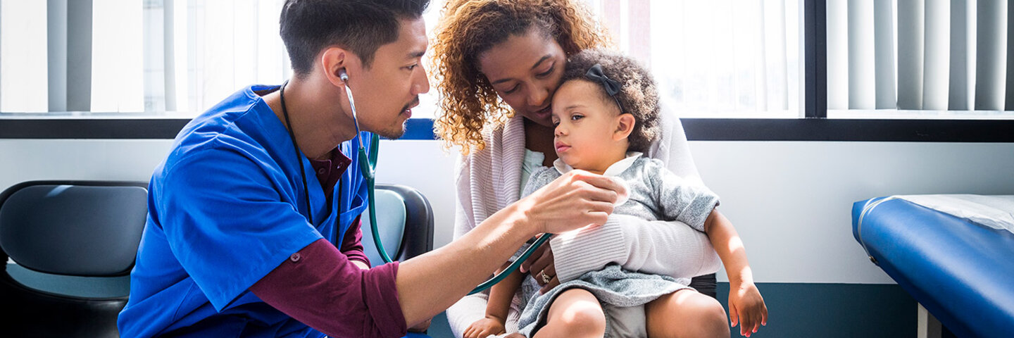 male nurse listening to a young patients heart beat