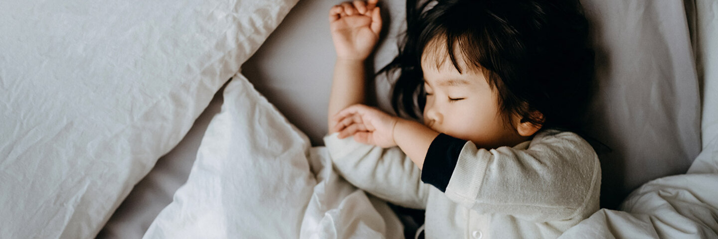 young child sleeping in bed