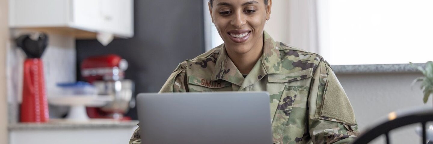 Air Force Service Member at home writing on laptop