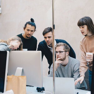 group of professional programmers looking at a shared monitor