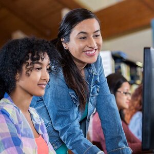 Young Hispanic teacher with female student